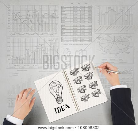Businessman hands drawing money making formula in notepad
