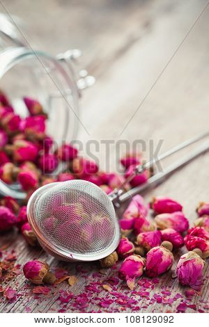Rose Buds Tea, Tea Strainer And Glass Jar On Rustic Wooden Table. Retro Styled.
