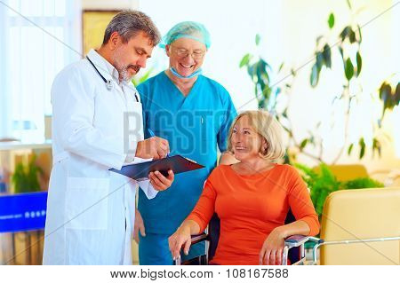 Happy Doctor And Surgeon Consulting Patient About Treatment Before Discharging From Hospital