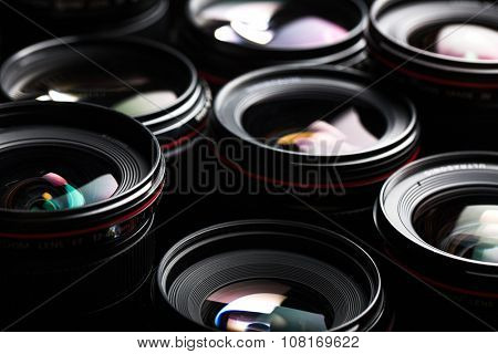 Modern camera lenses with reflections, low key image