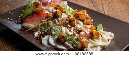 Decorated tagliatelle with cheese sauce, mushrooms and chicken