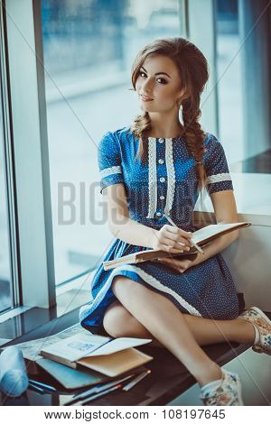 Young girl with old books in vintage dress