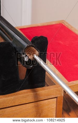 Cleaning an over/under style shotgun, inserting the brush on the cleaning rod into the upper chamber from the breach end