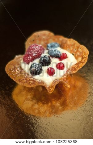 Caramel tartlet with fresh berries and cream