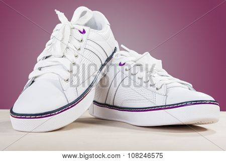 Fashion Ideas And Concepts. Fashionable Stylish White Plimsolls On Wooden Surface