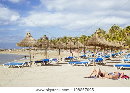 Straw Umbrellas And Loungers On The Playa De Las Americas, Tenerife