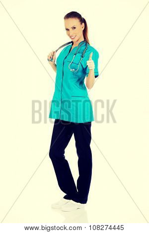 Beautiful smiling woman doctor with thumbs up.