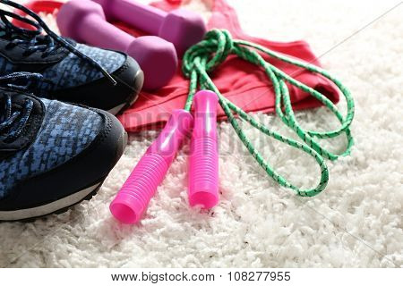 Sport clothes and equipment on white carpet background
