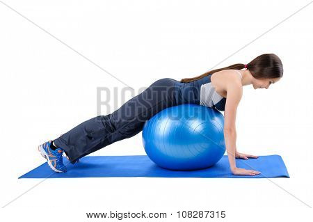 Young woman shows starting position of Fitness Stability Ball Glute Kickback Workout, isolated on white