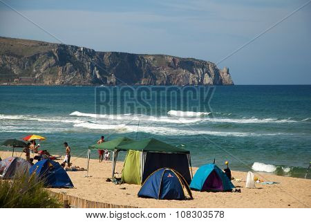 Bugerru Italy-JUNE 11: Unidentified people in the beach with rough sea and cliff behind in summertime on June 11.2012 in Bugerru Italy as editorial