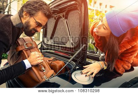 Beautiful Fashion Couple Going To Vacations, Loading Their Car Boot With Leather Travel Suitcases  -