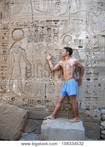 A Man In His Boxers On The Background Of The Relief With The God Khonsu In Egypt