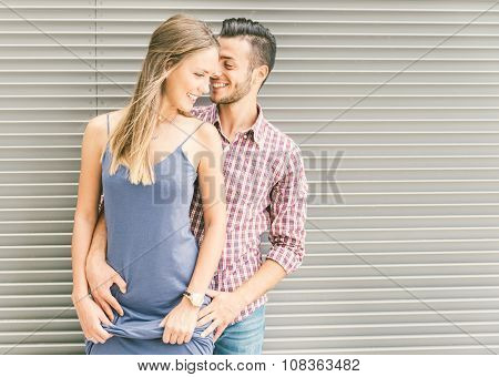Happy Couple Posing Against A Steel Background