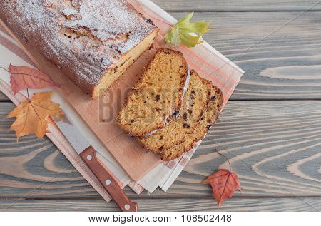 Homemade cake with dried apricots and raisins on wooden background.  Autumn still life.