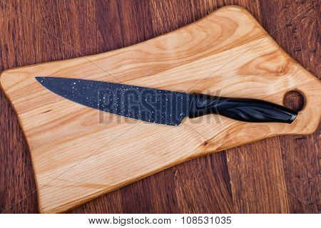 Knife on cutting boardon a woodwn table