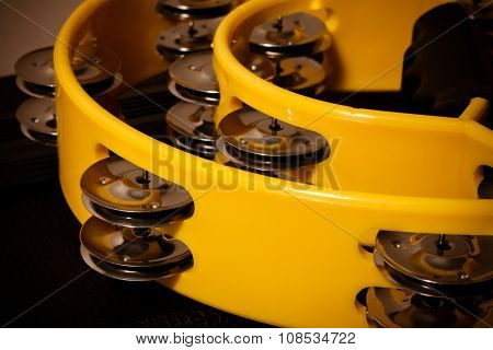 the yellow tamborine on the black background.