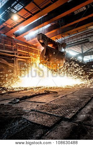 from ladle pours red-hot steel