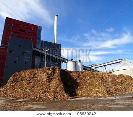 Bio Power Plant With Storage Of Wooden Fuel Against Blue Sky