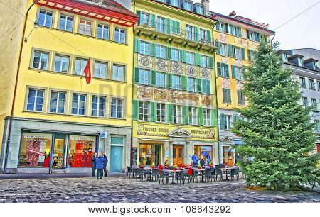 LUCERNE SWITZERLAND - JANUARY 04 2015: Street cafe near a beautiful Christmas tree on the right bank of the River Reuss at a picturesque square Muhlenplatz in Lucerne Switzerland.