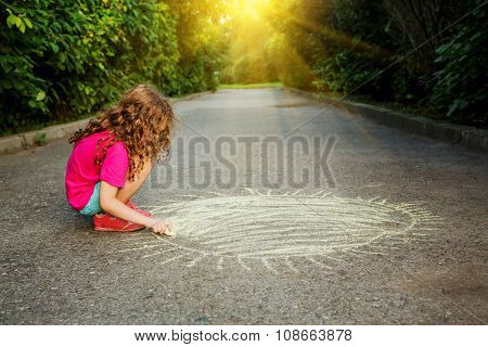 Child Paints The Sun On The Asphalt In A Sunset Light.