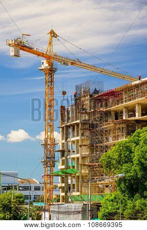 Yellow crane in Construction Site on blue sky.