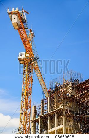 Yellow crane in Construction Site on blue sky.
