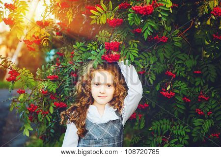 Schoolgirl With A White Shirt And A Sundress Near A Mountain Ash Tree.