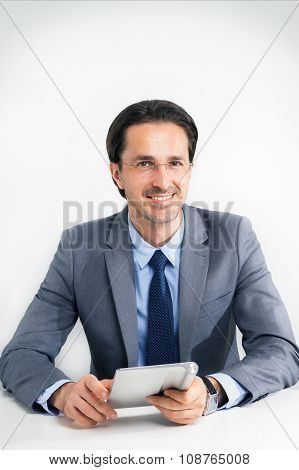 The Friendly Manager Wearing Spectacles Works With The Tablet