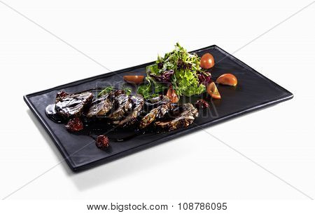 Fried slices of veal with salad mix on white background
