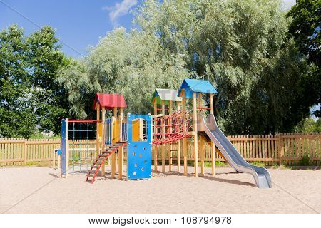 childhood, equipment and object concept - climbing frame with slide on playground outdoors at summer