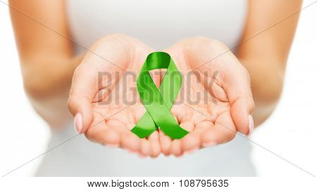 healthcare and medicine concept - female hands holding green organ transplant awareness ribbon