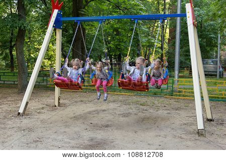 Four Clones Of Cute Little Girl Swinging On Swing