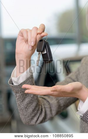 Salesperson is representing car keys set.