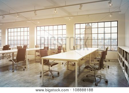 Workplaces In A Bright Sunset Loft Open Space Office. Empty Tables And Docents' Book Shelves. New Yo