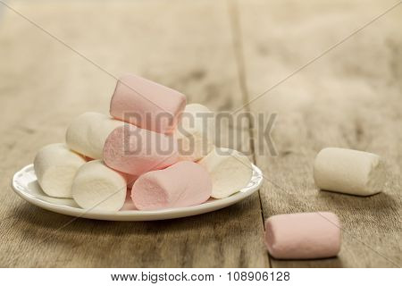 Sweet Marshmallows On White Plate On Wooden Background
