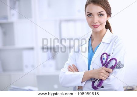 Portrait of happy successful young female doctor holding a stet