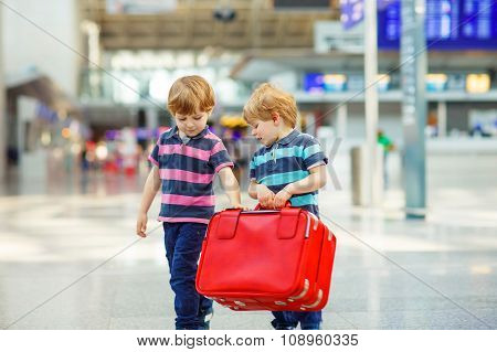 Two tired little sibling boys at the airport