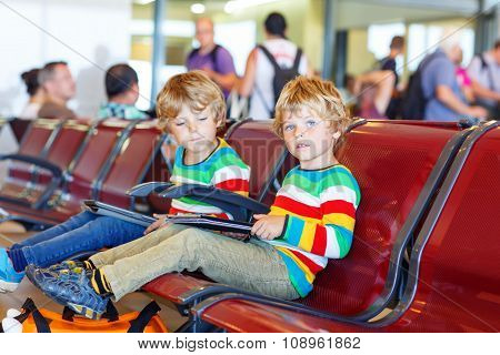 Two tired little sibling boys at the airport