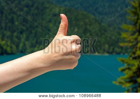 Thumb on the background of a lake