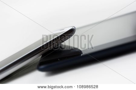 White Smartphone Leaning On A Tablet