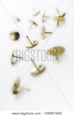 A Small Collection Of Thumbtacks In A White Box - Crooked Angle