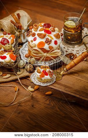 Traditional Easter cake with decorations and cupcakes on wooden table