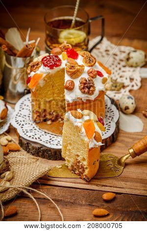 Traditional Easter cake with decorations and cupcakes on wooden table