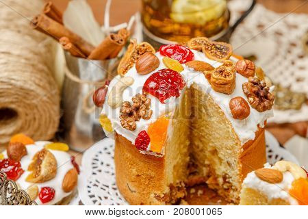 Traditional Easter cake with decorations and cupcakes on wooden table