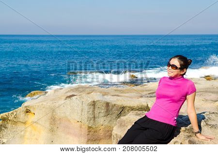 Asian girl explores the coastline of Bondi Beach in SydneyAustralia.