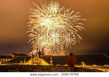 Guy watching fireworks in the local festival of San Froilan in Lugo. Spain.