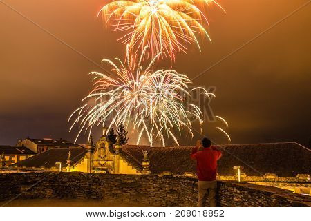 Guy watching fireworks in the local festival of San Froilan in Lugo. Spain.