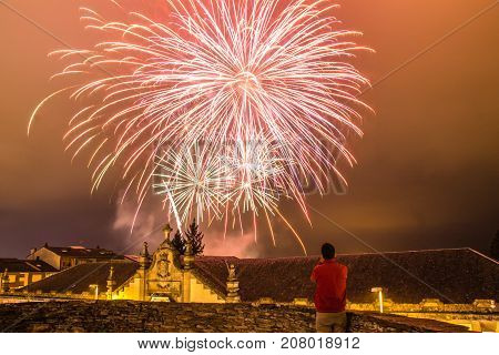 Guy watching fireworks in the local festival of San Froilan in Lugo. Spain.
