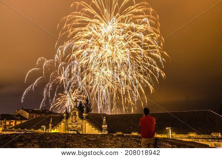 Guy watching fireworks in the local festival of San Froilan in Lugo. Spain.