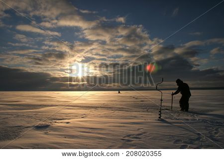 Fisherman On The River Covered With Ice